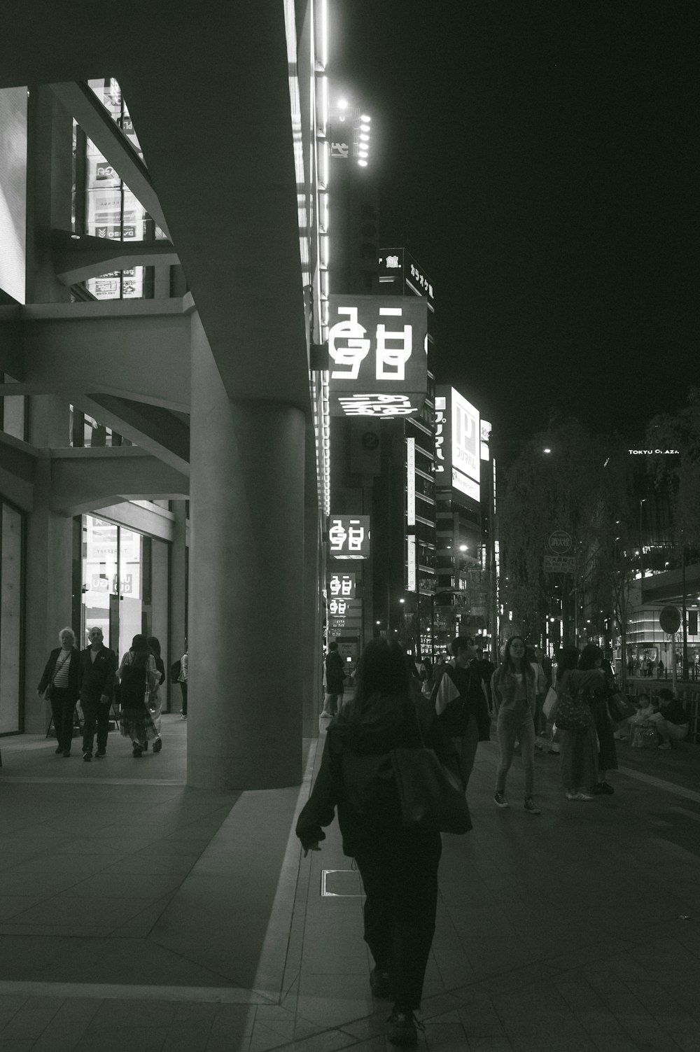 a group of people walking down a street at night