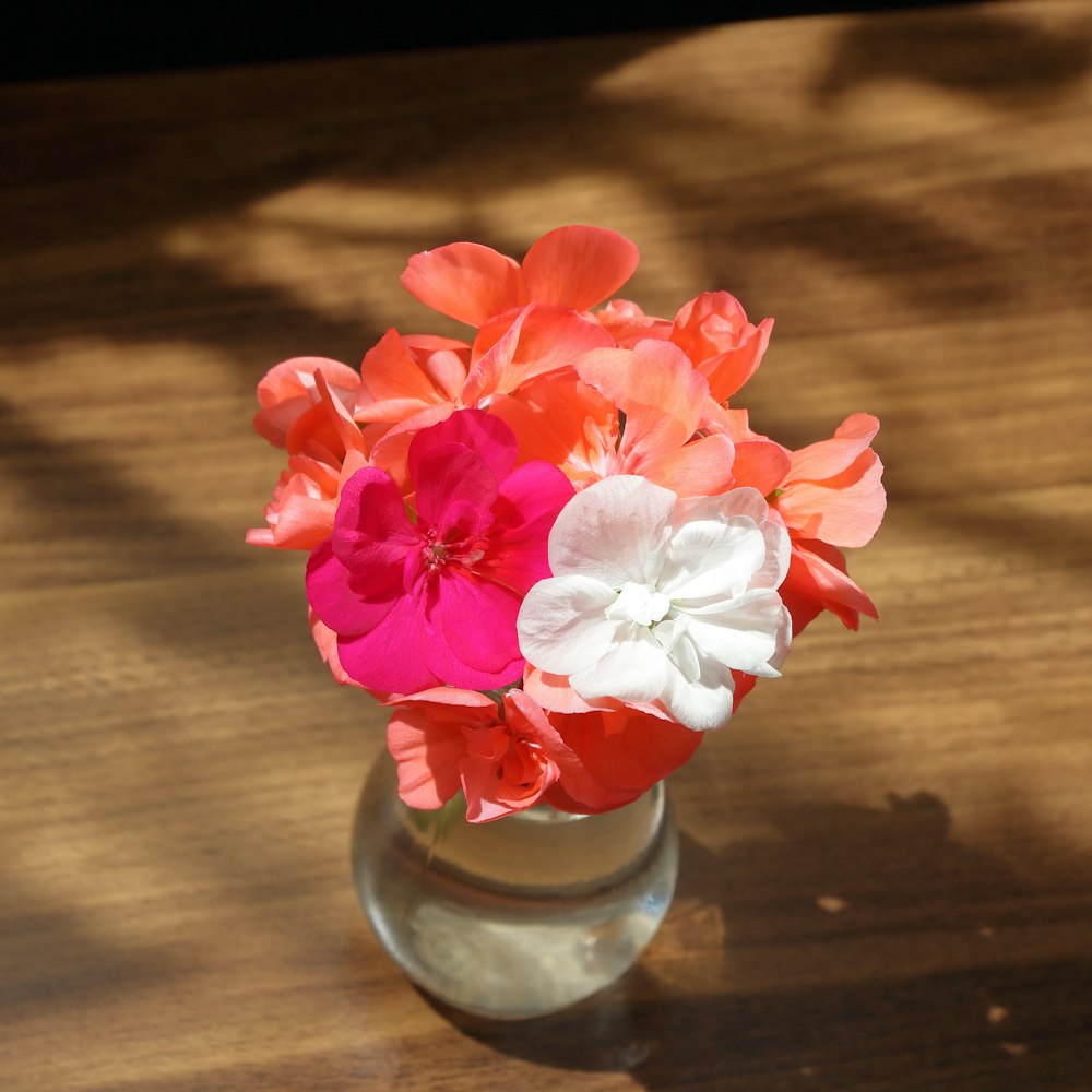 a vase filled with flowers on top of a wooden table