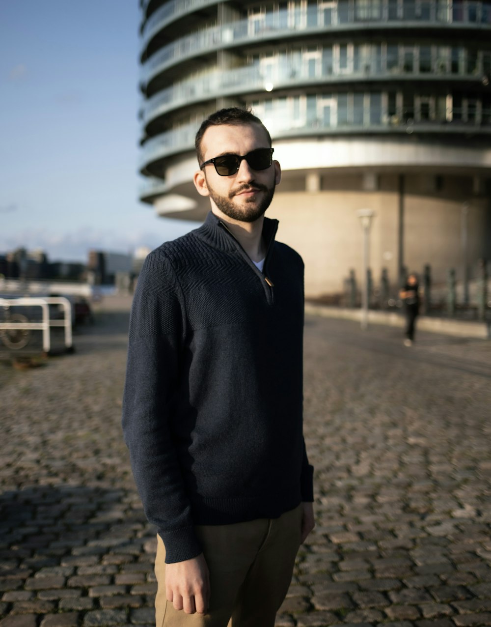 a man standing in front of a tall building