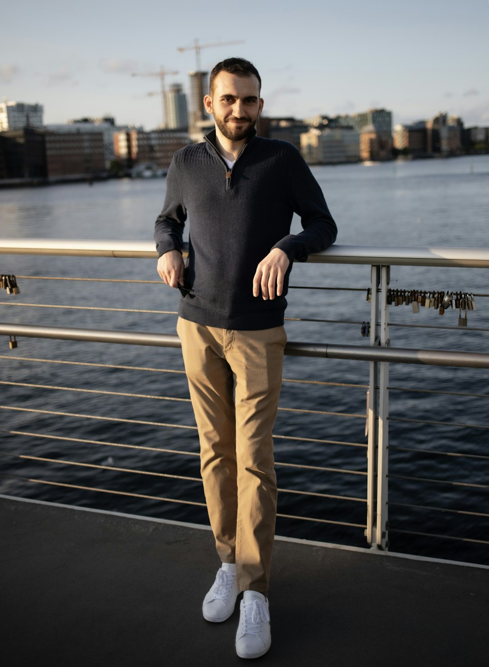 a man standing on a bridge next to a body of water