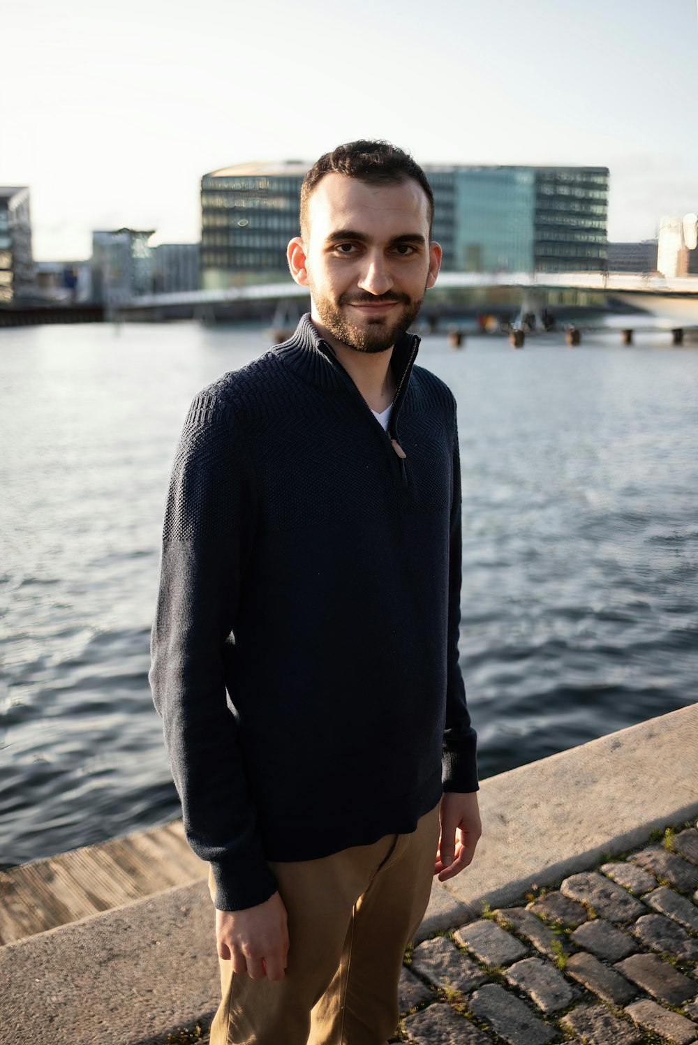 a man standing on a dock next to a body of water