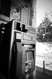 a black and white photo of a pay phone