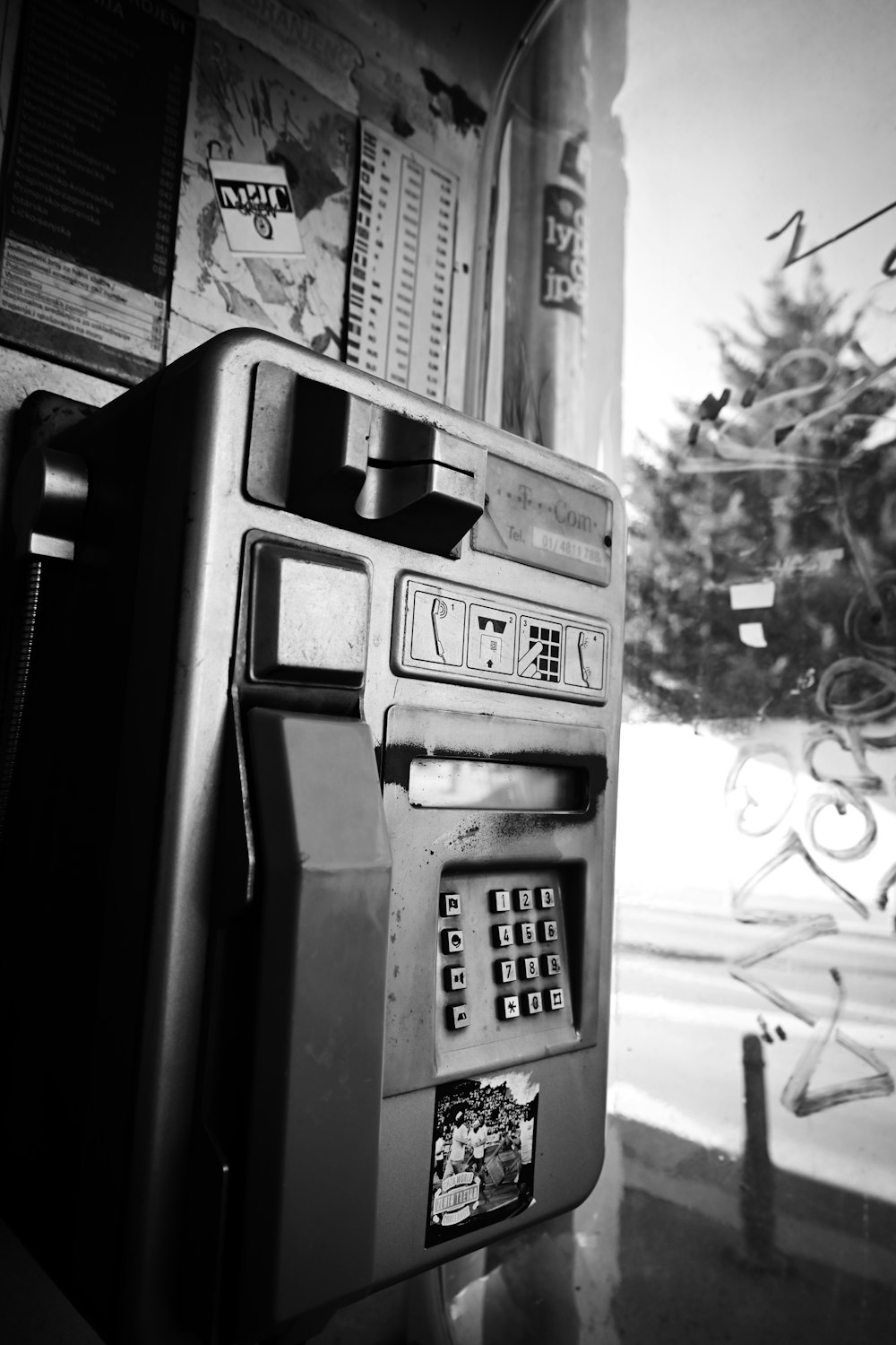 a black and white photo of a pay phone