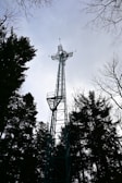 a tall metal tower with a cross on top of it