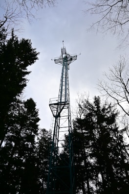 a tall metal tower with a cross on top of it