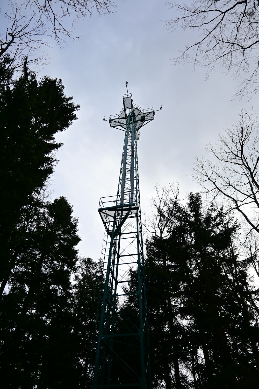 a tall metal tower with a cross on top of it