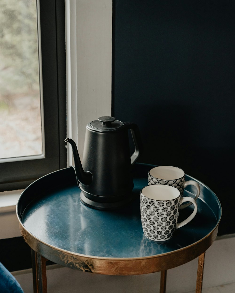 a table with two cups and a teapot on it