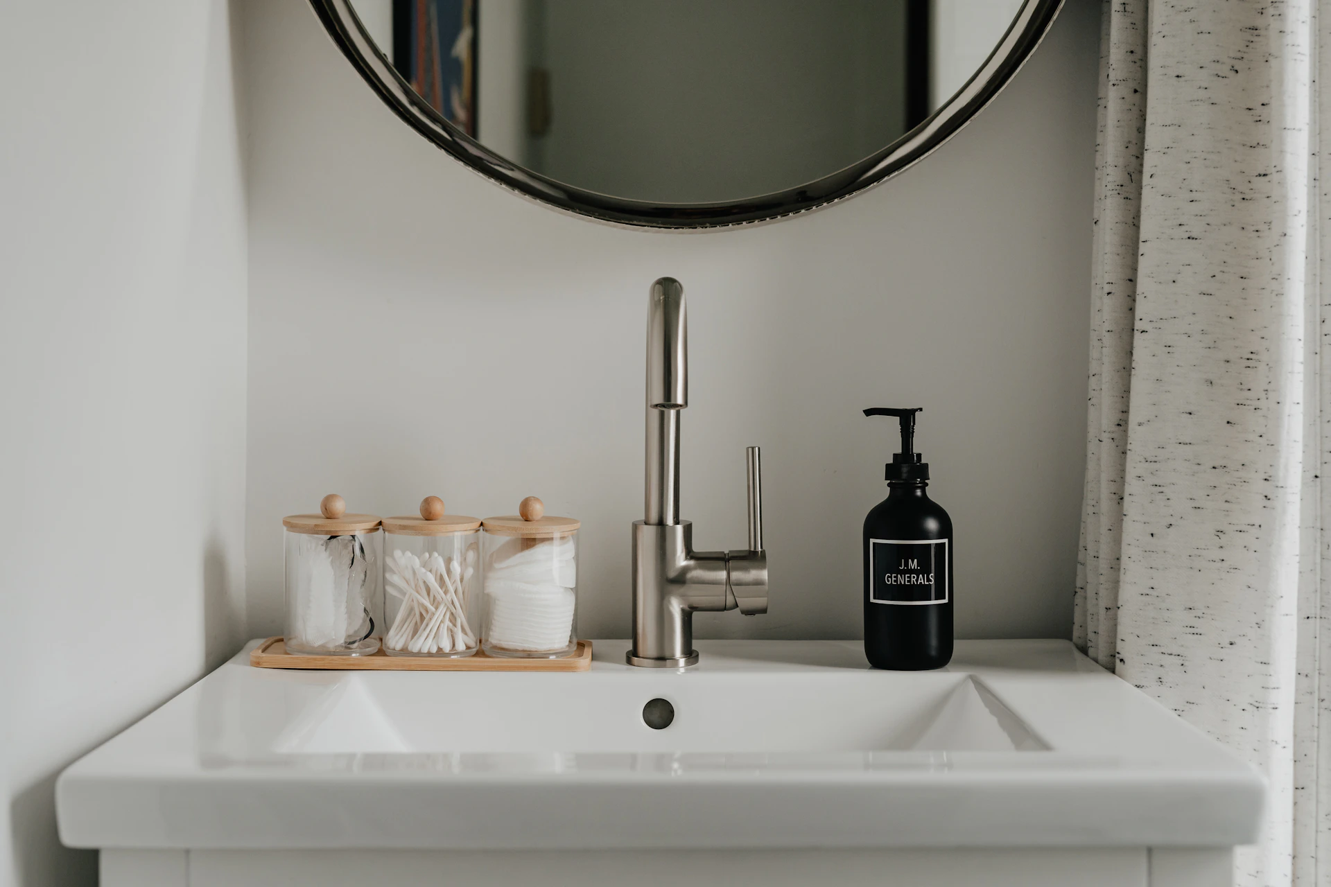 a bathroom sink with a soap dispenser next to it
