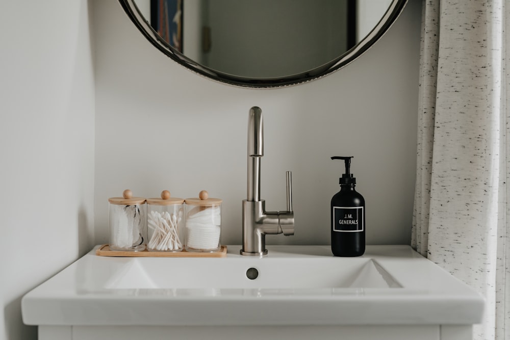 a bathroom sink with a soap dispenser next to it