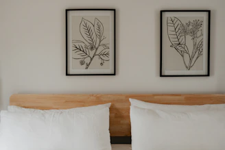 a bed with two framed pictures above it
