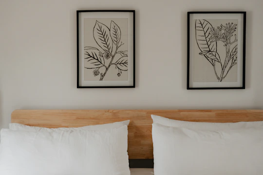 a bed with two framed pictures above it