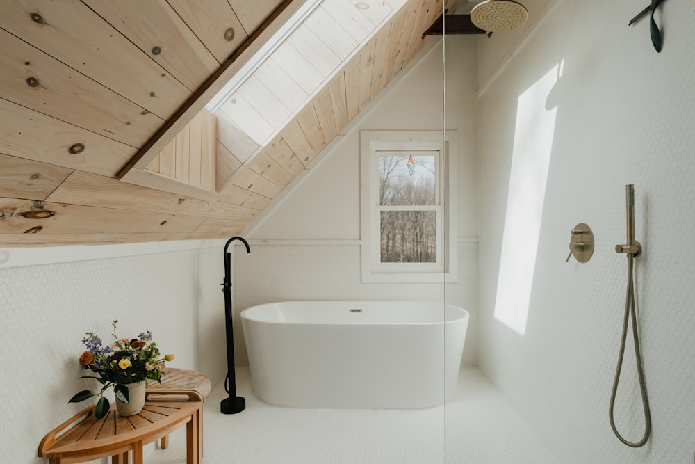 a bathroom with a wooden ceiling and a white bathtub