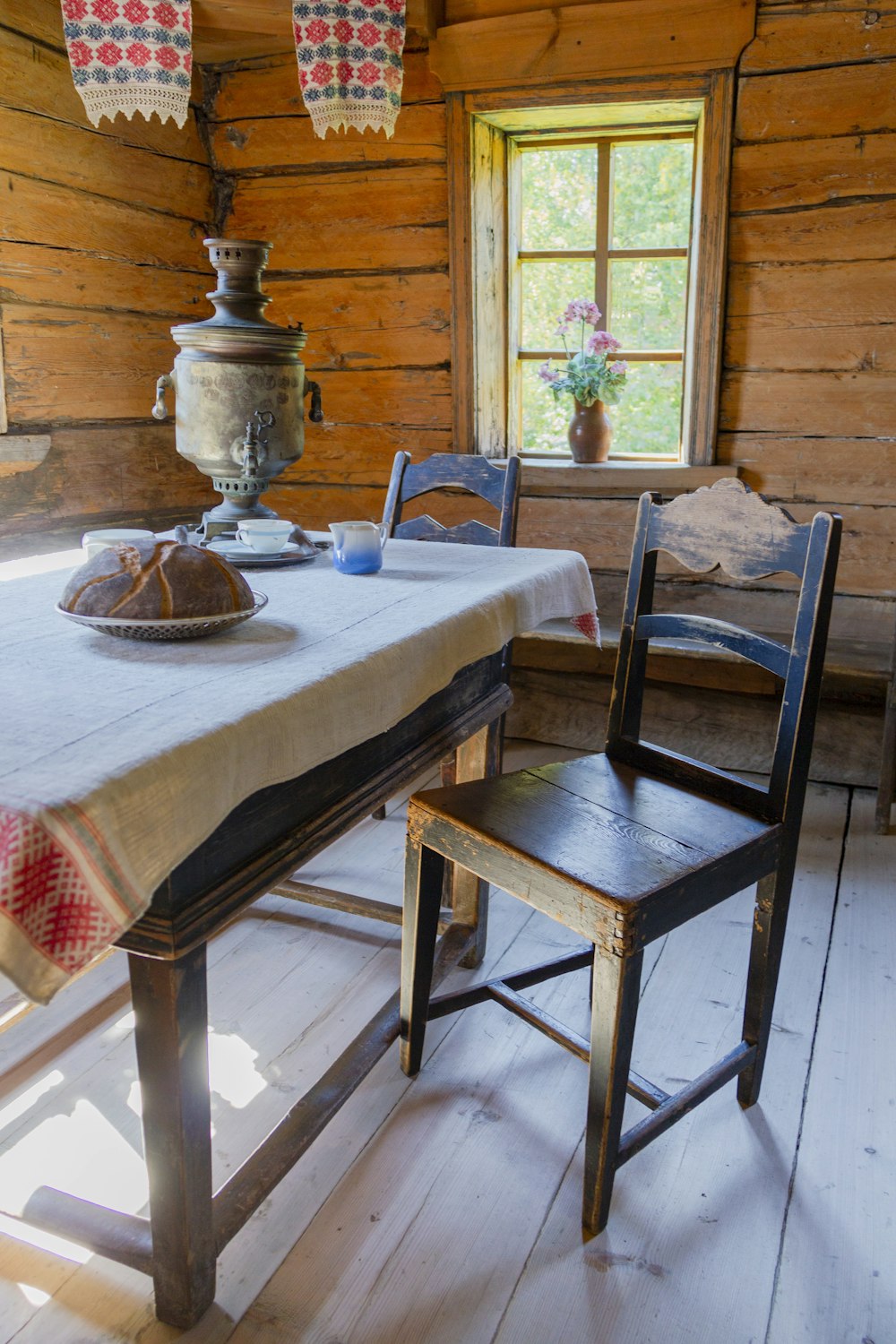 a table and chairs in a room with wooden walls