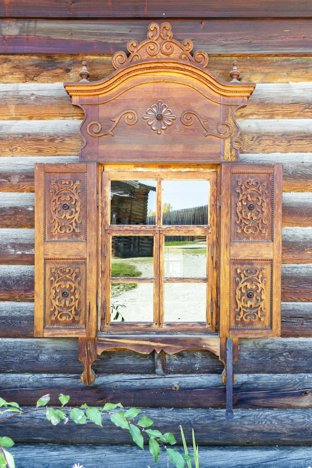 a wooden window with a mirror on the side of it