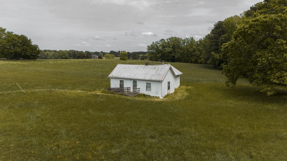 a small white house in a grassy field