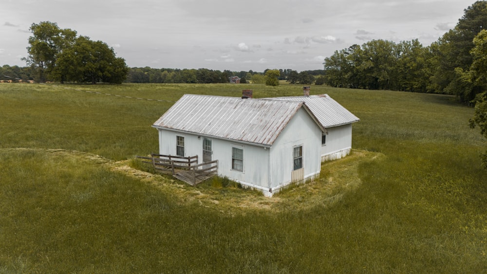 a small white house in a grassy field