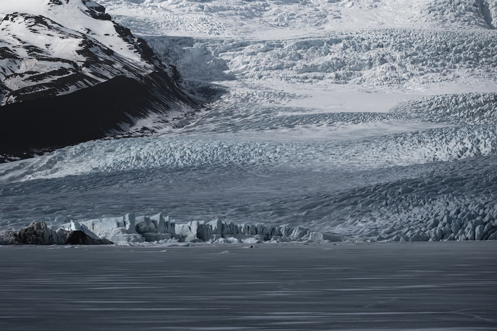 a large glacier with a mountain in the background