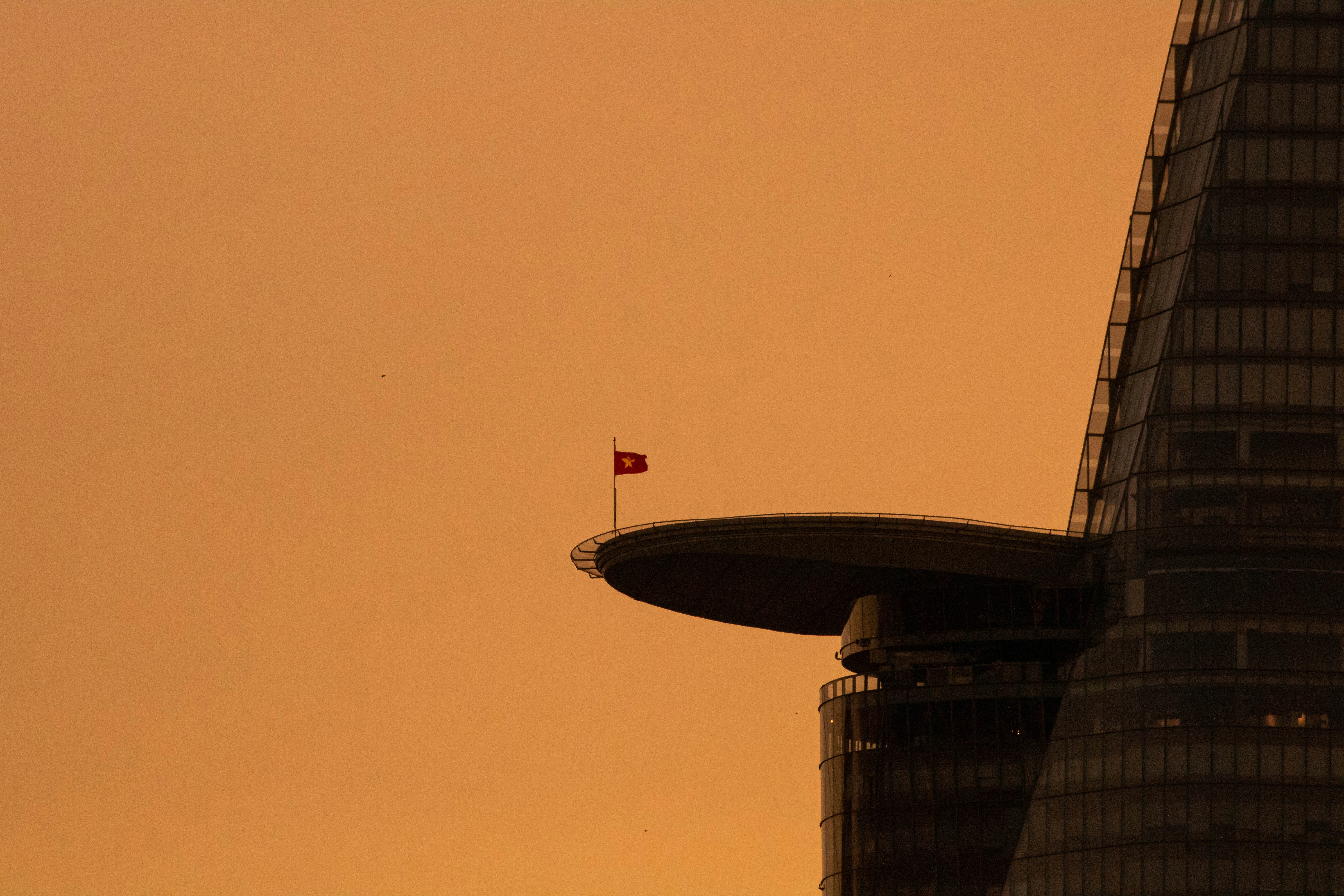 Un edificio alto con una bandera en la parte superior