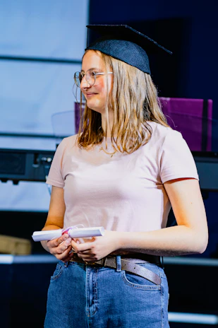 a woman in a cap and glasses holding a remote