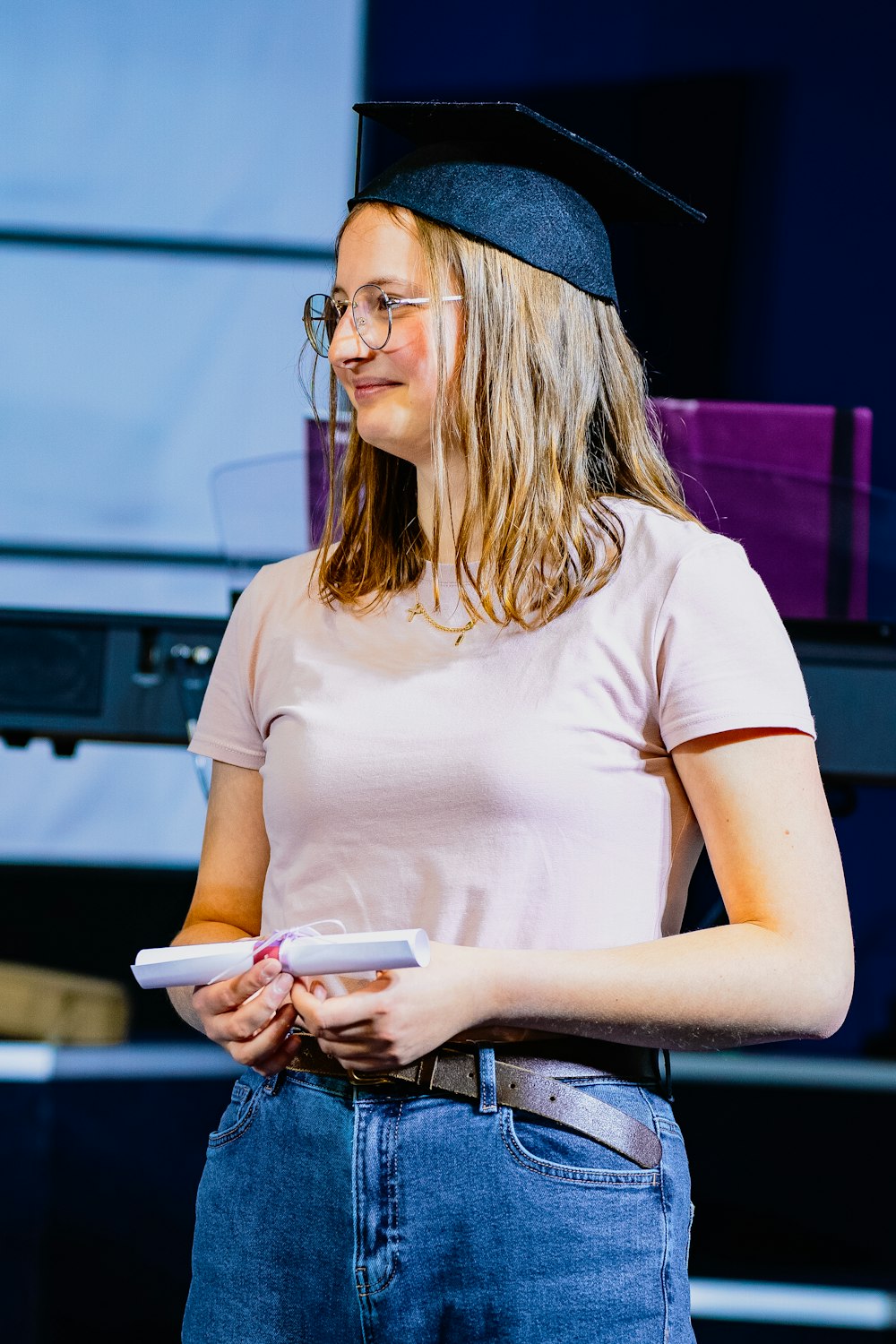 a woman in a cap and glasses holding a remote