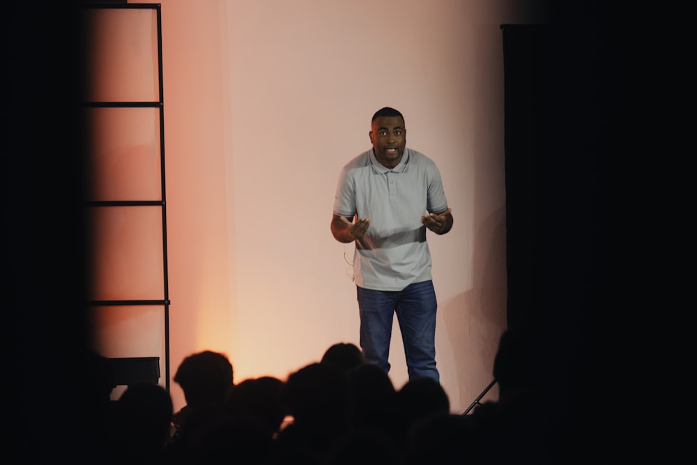 a man standing on a stage giving a presentation
