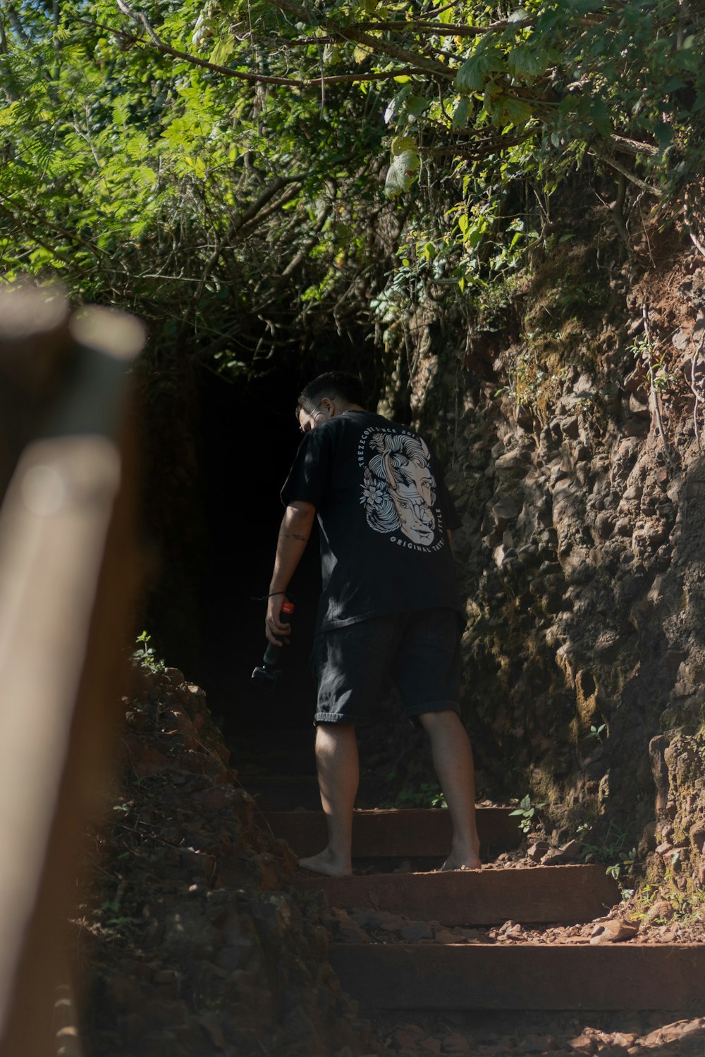 a man walking up some stairs in the woods