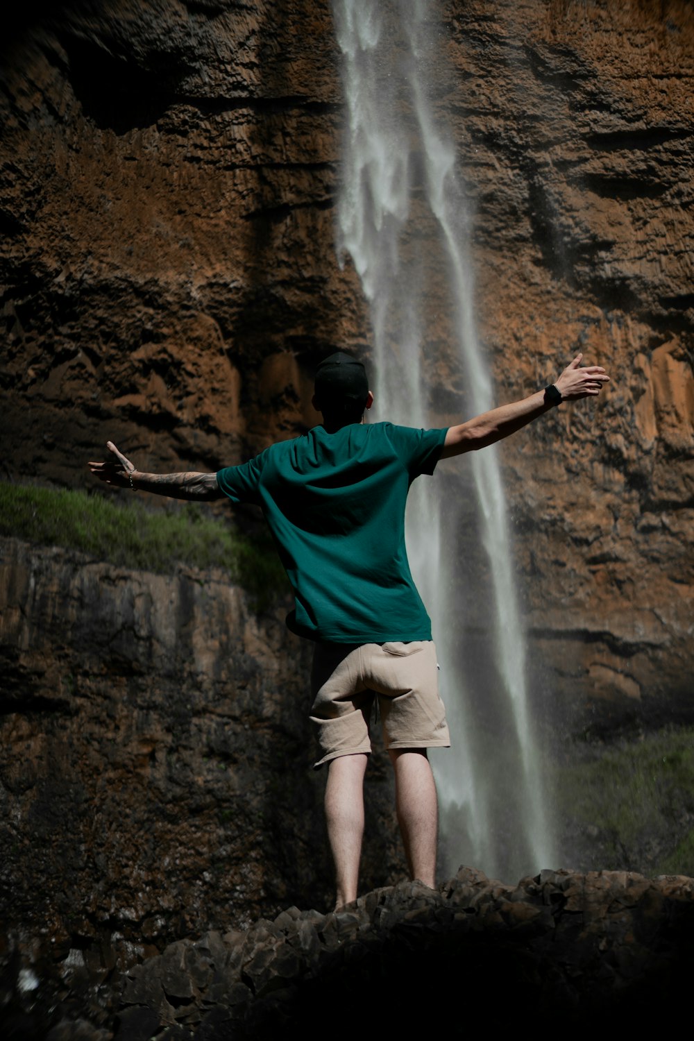 a man standing in front of a waterfall