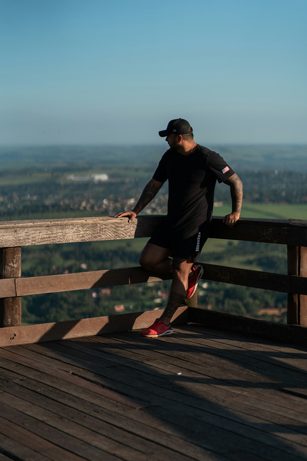 a man leaning on a wooden rail on top of a wooden deck