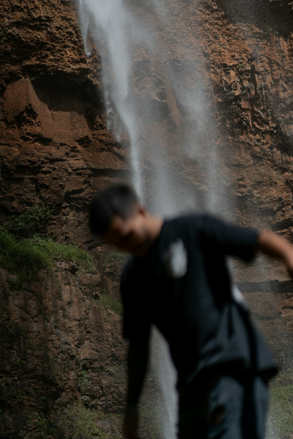 a man standing in front of a waterfall