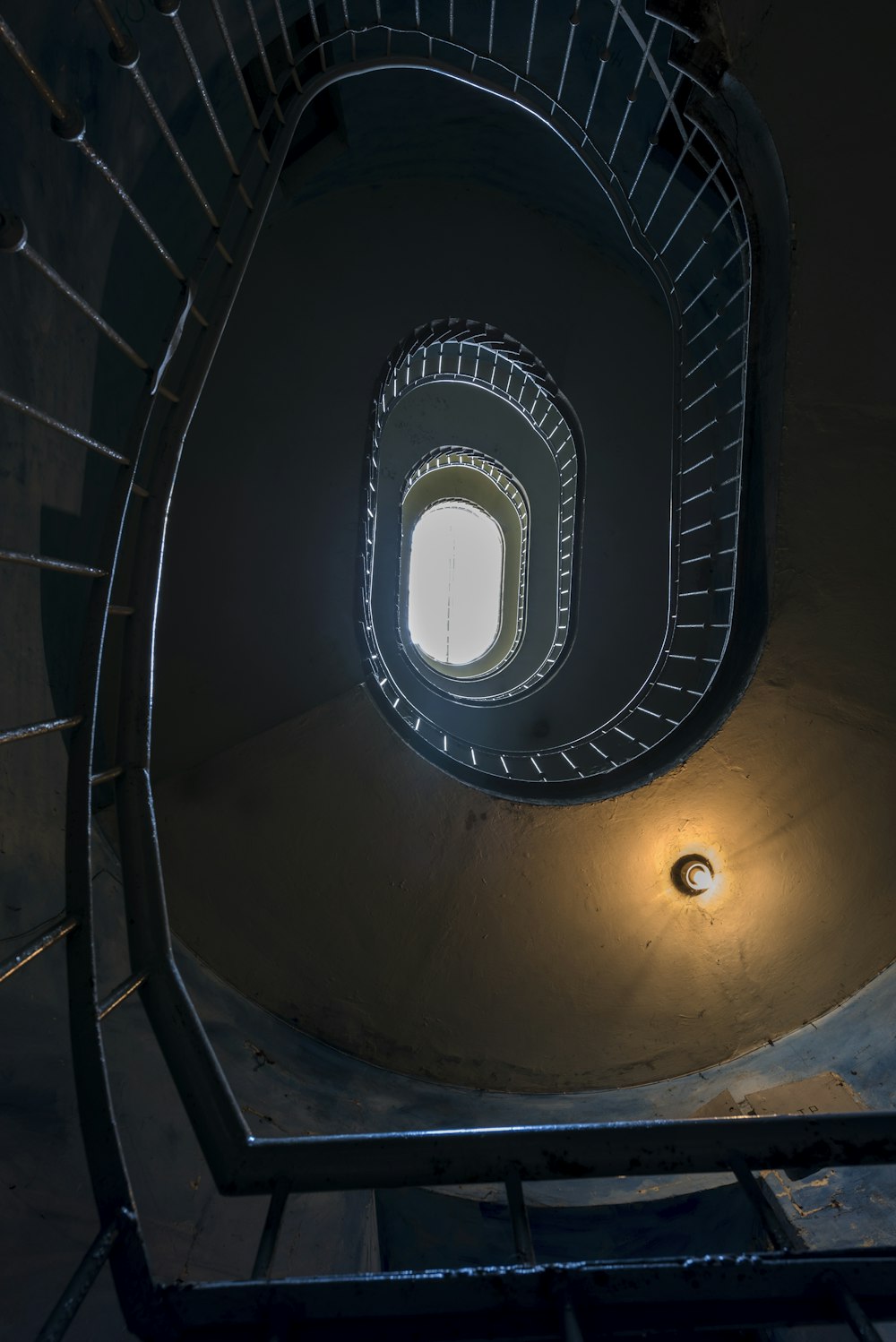 a spiral staircase with a light at the end