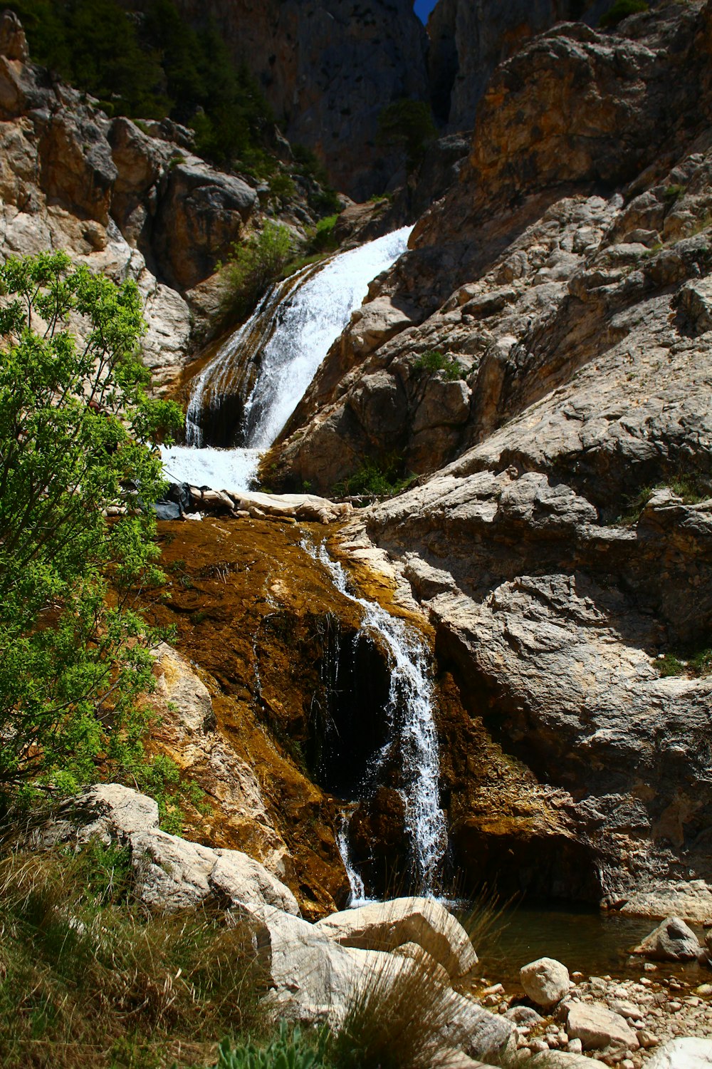 a small waterfall in the middle of a rocky area