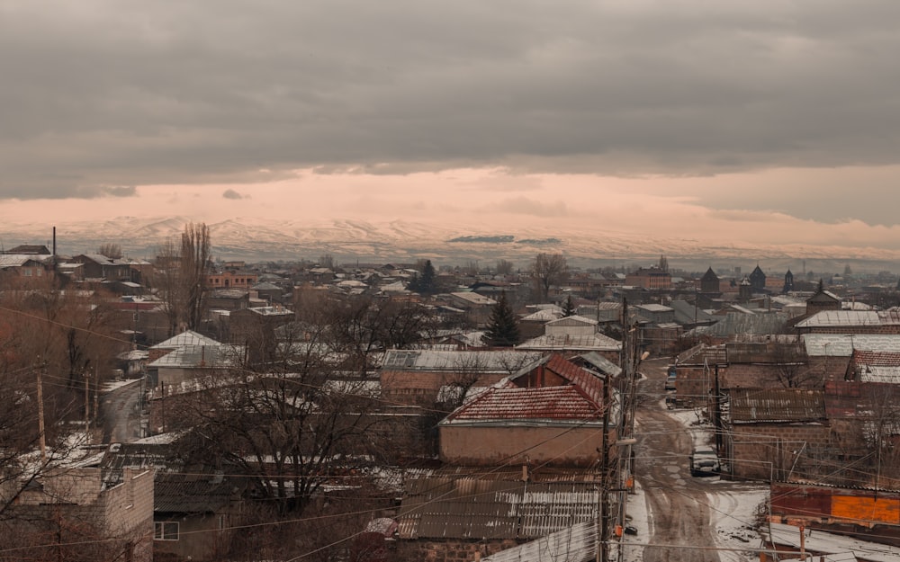 a view of a city with snow covered mountains in the background