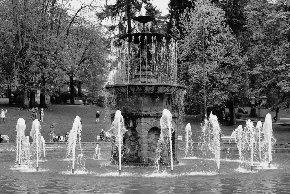 a black and white photo of a fountain in a park