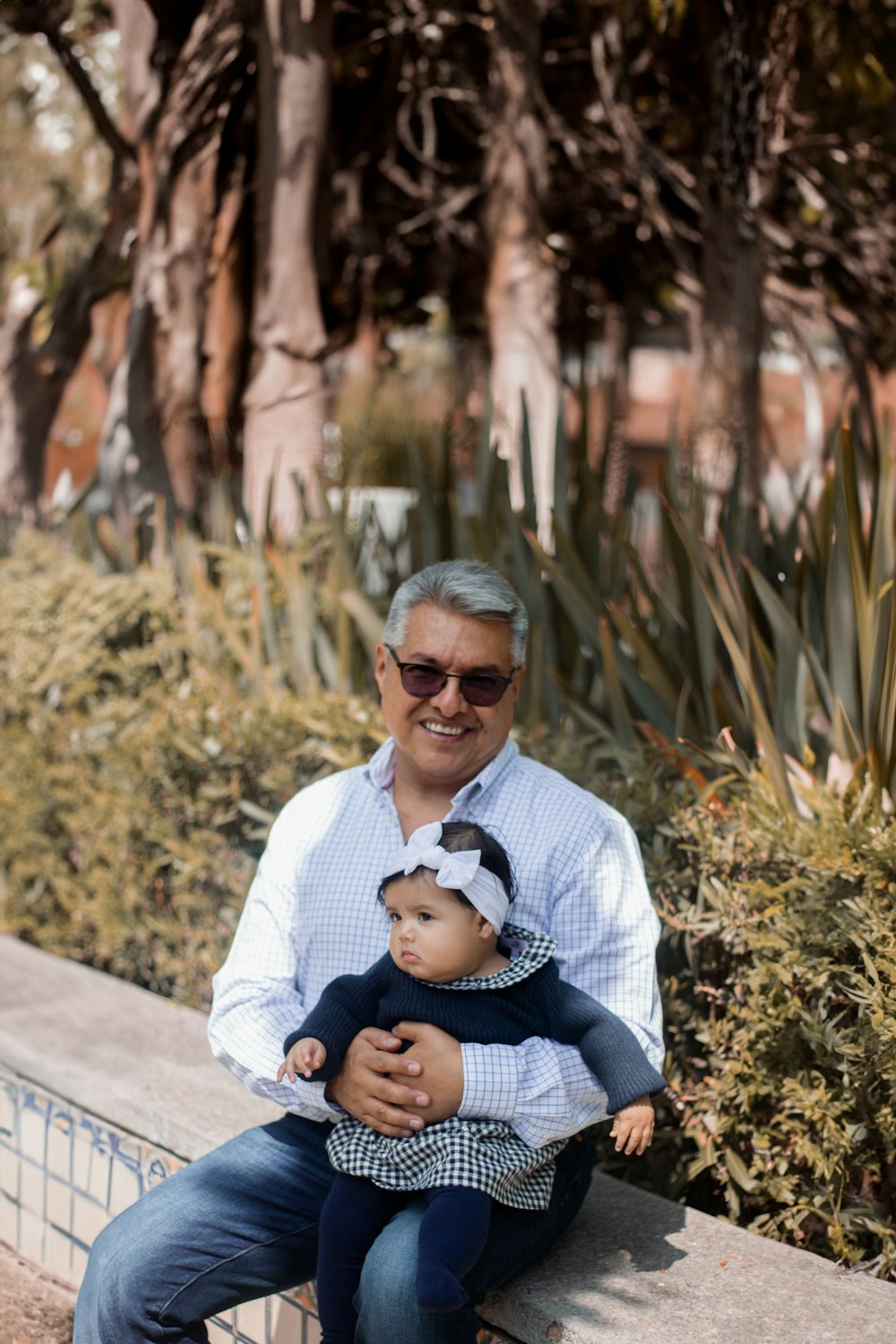 a man sitting on a bench holding a small child