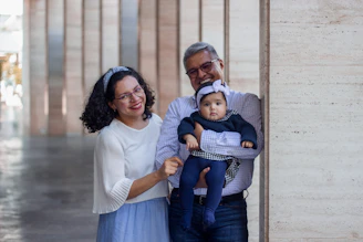 a man and a woman holding a baby in their arms