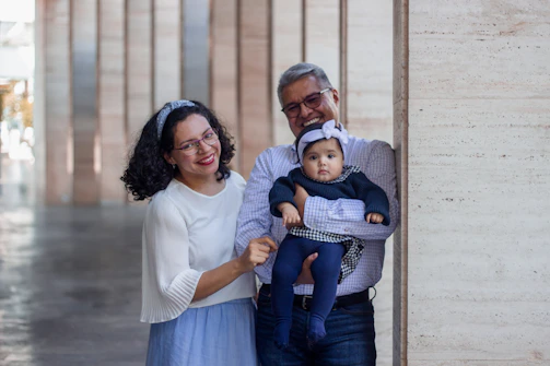 a man and a woman holding a baby in their arms