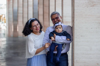 a man and a woman holding a baby in their arms