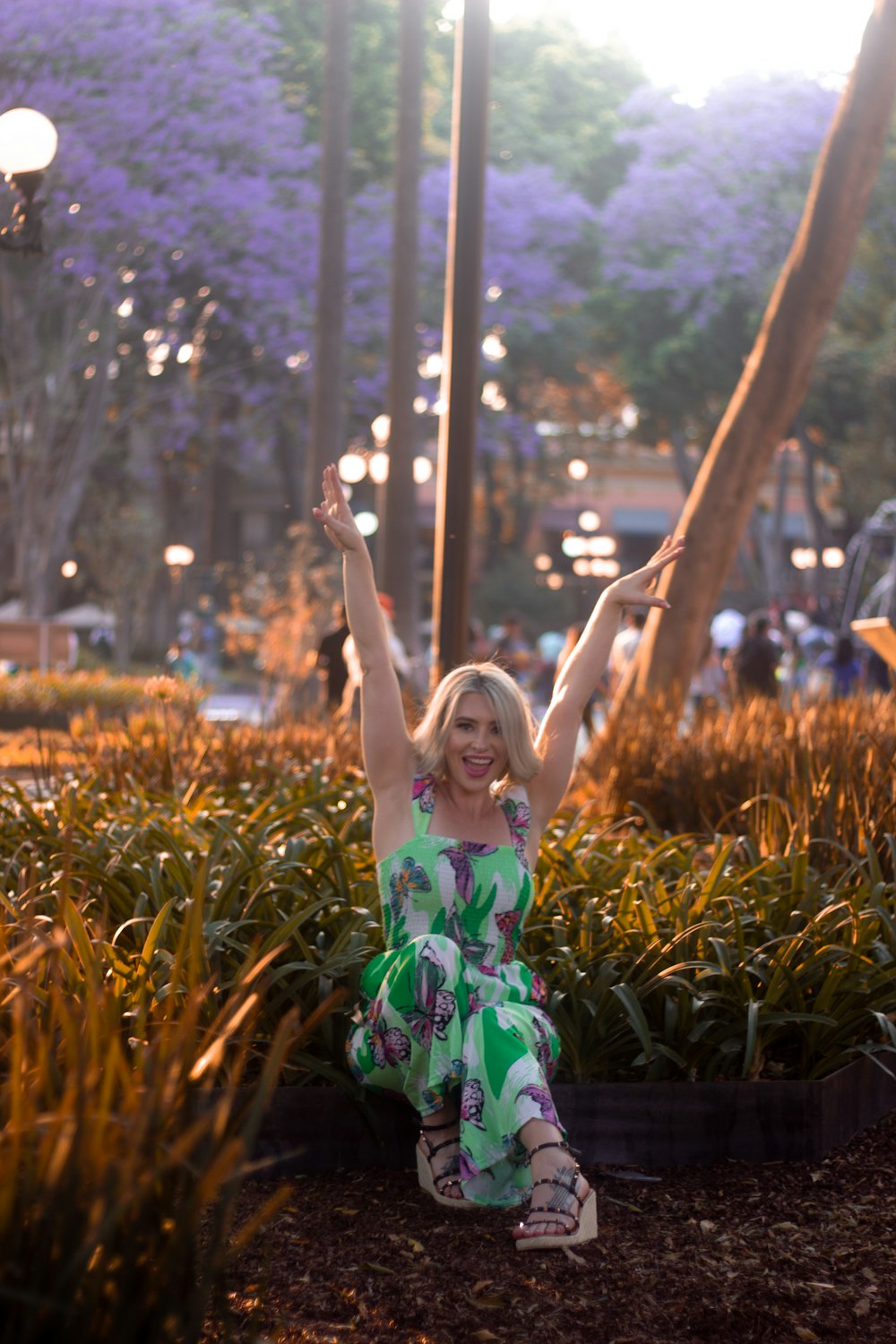 a woman sitting on the ground with her arms in the air