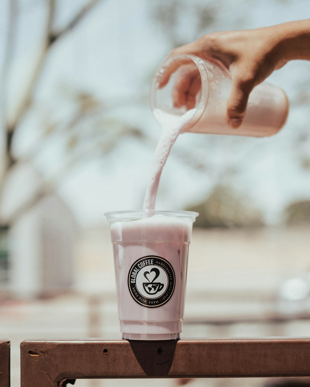 a person pours milk into a cup