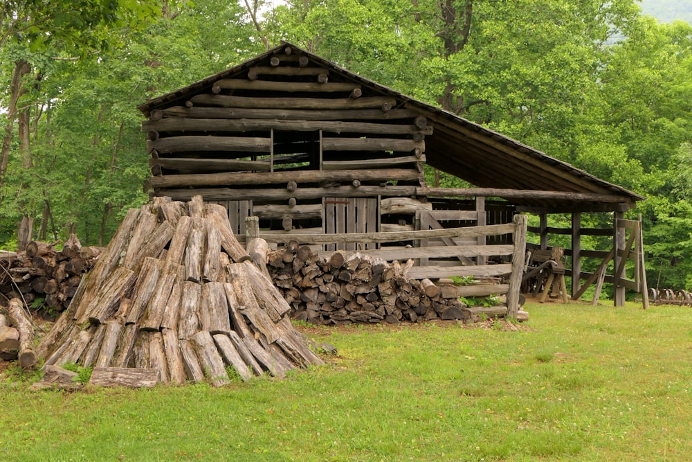 a log cabin with a pile of logs in front of it