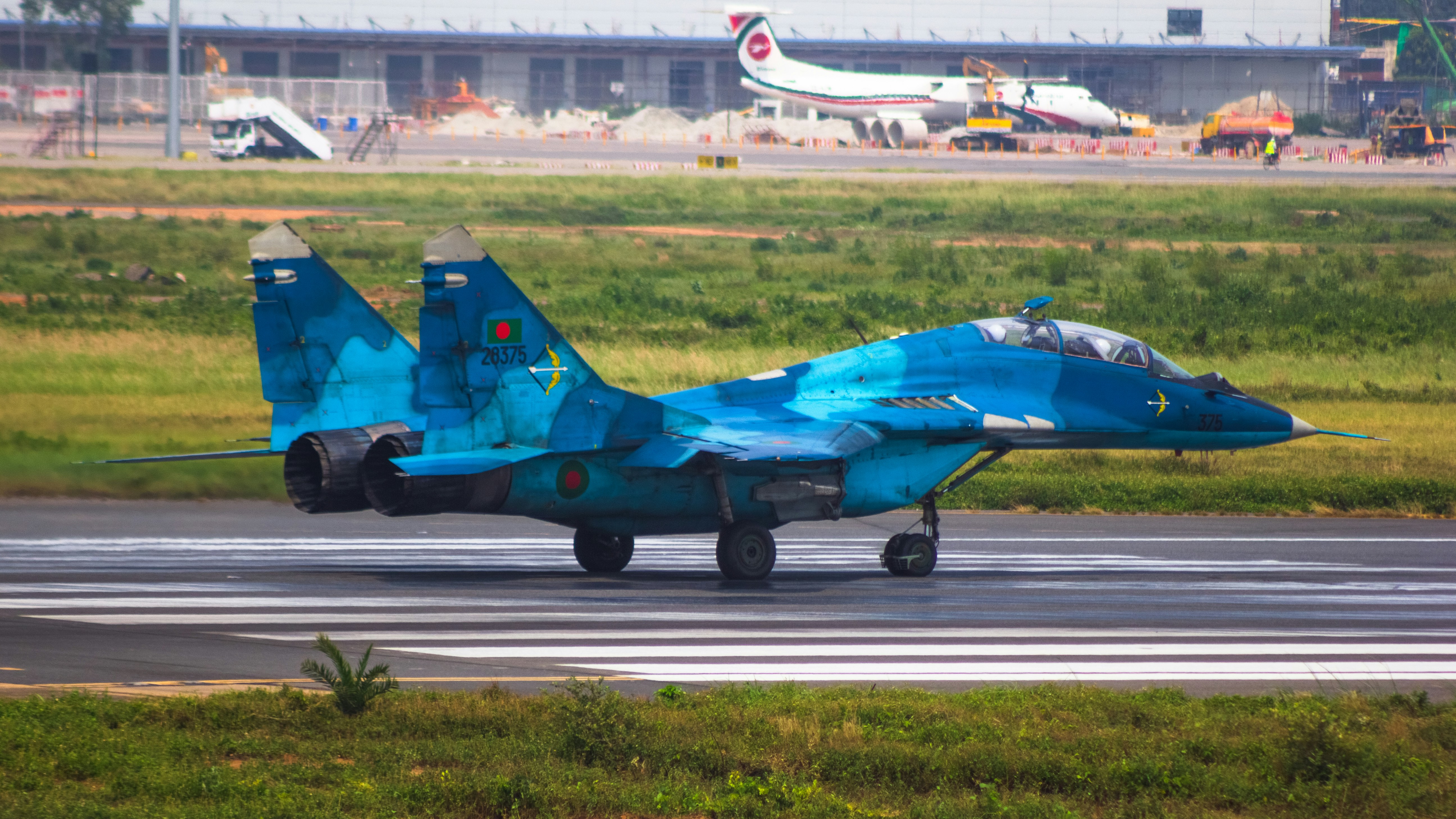 a blue fighter jet sitting on top of an airport runway, Bangladesh Air Force MiG 29