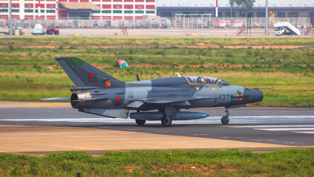 a fighter jet sitting on top of an airport runway