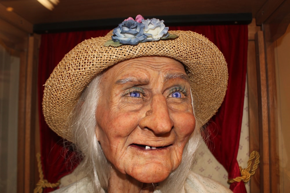 an old woman wearing a straw hat with a flower on it