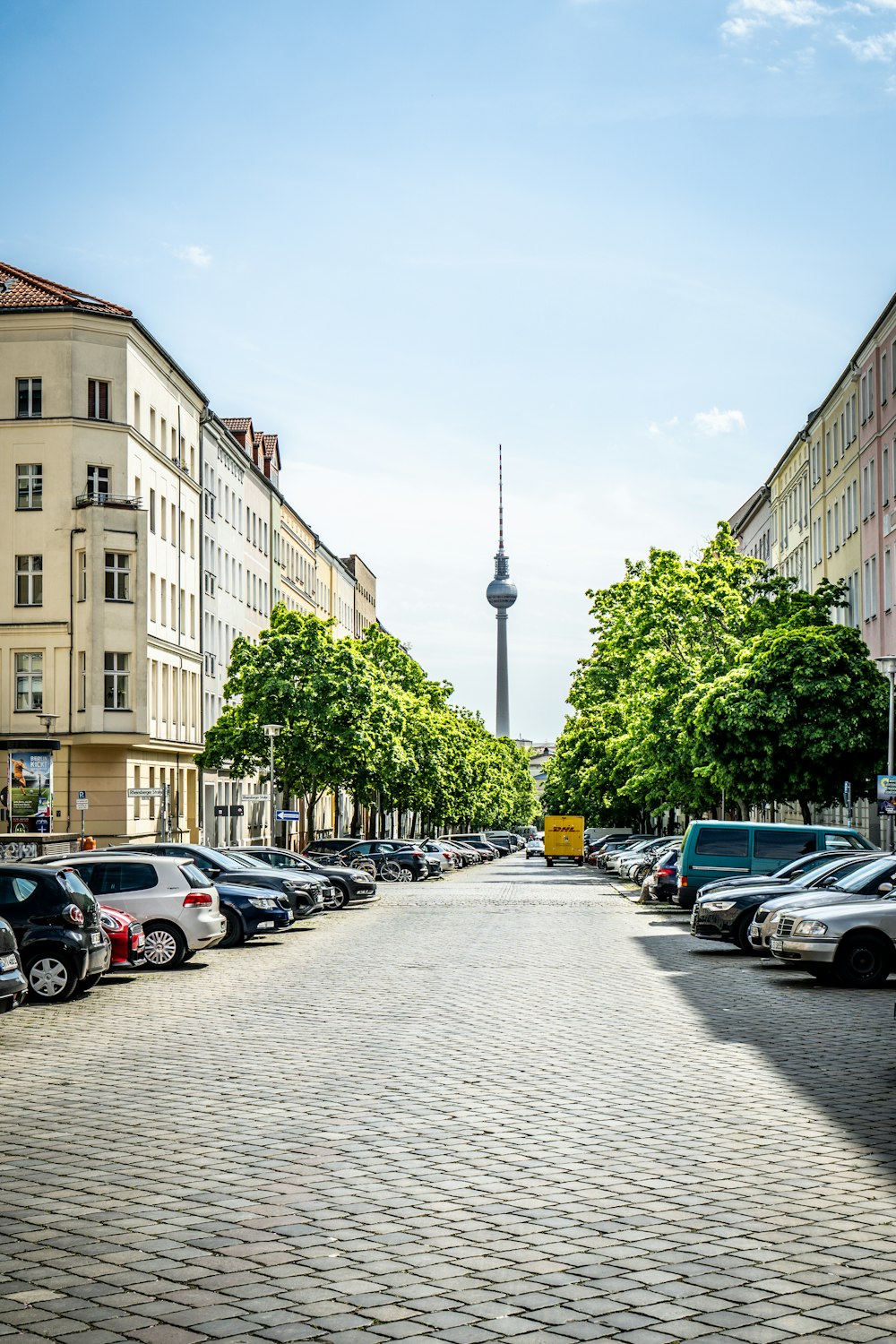 a street lined with parked cars next to tall buildings