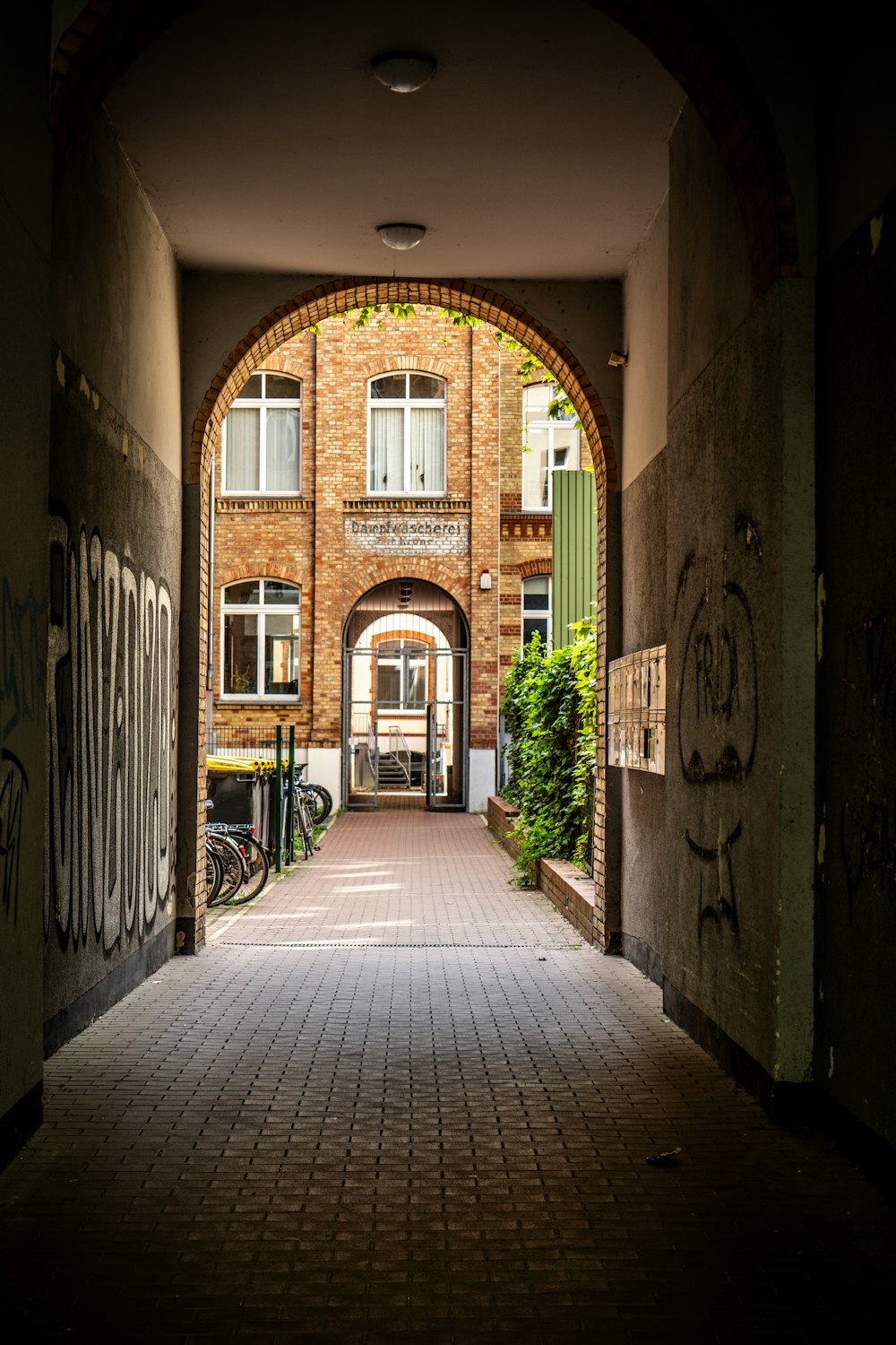 an archway leading to a building with graffiti on it