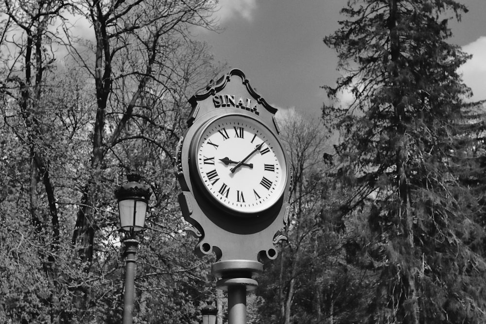 Una foto en blanco y negro de un reloj en un poste