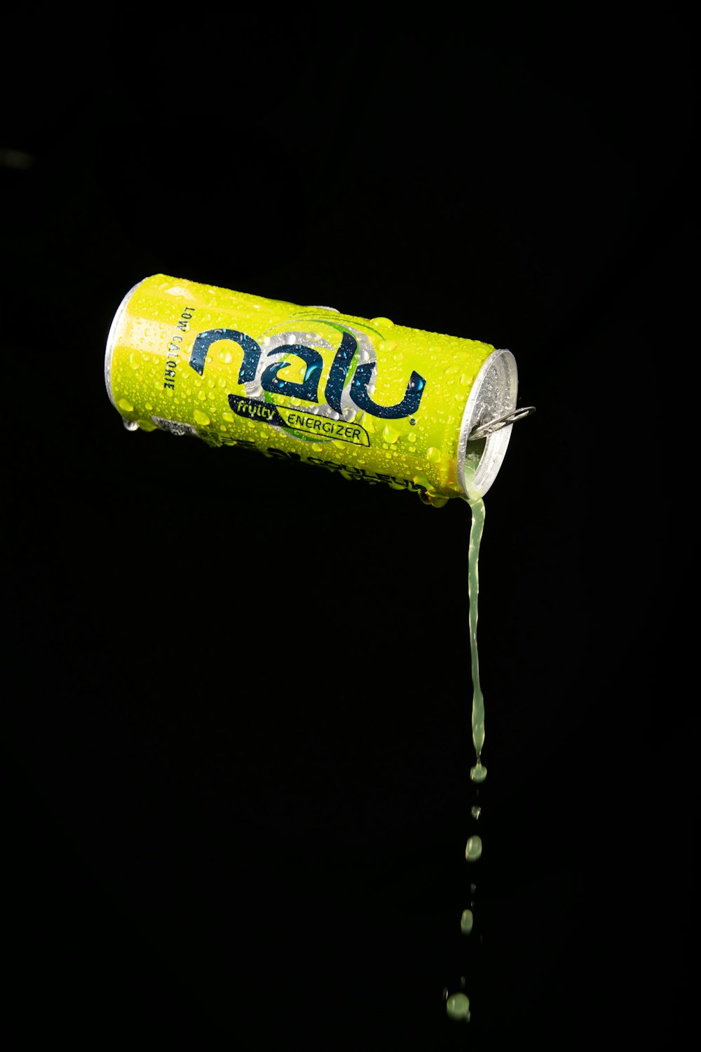 a can of soda being poured into a pool of water