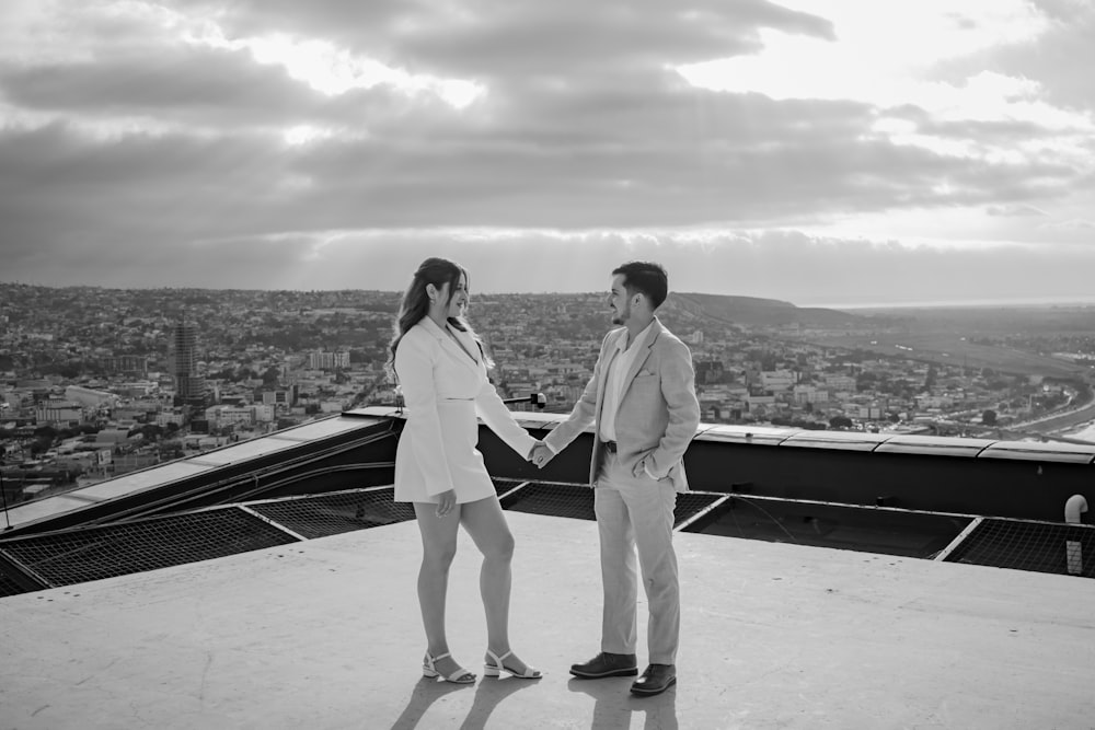 a man and a woman standing on top of a building