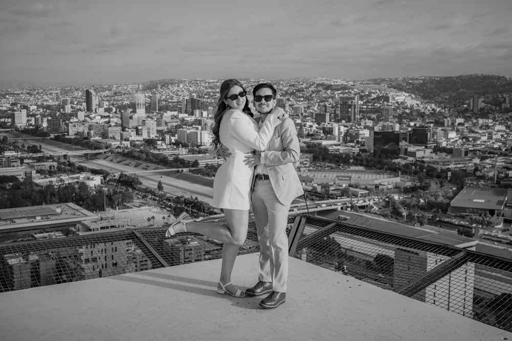a couple of women standing next to each other on top of a building