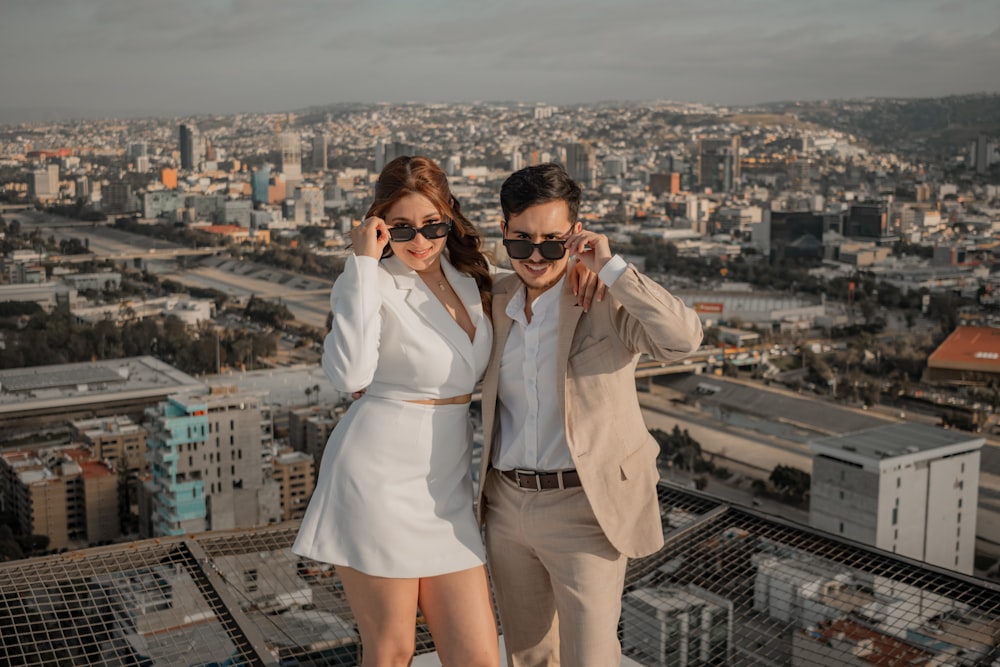 a man and a woman standing on top of a building